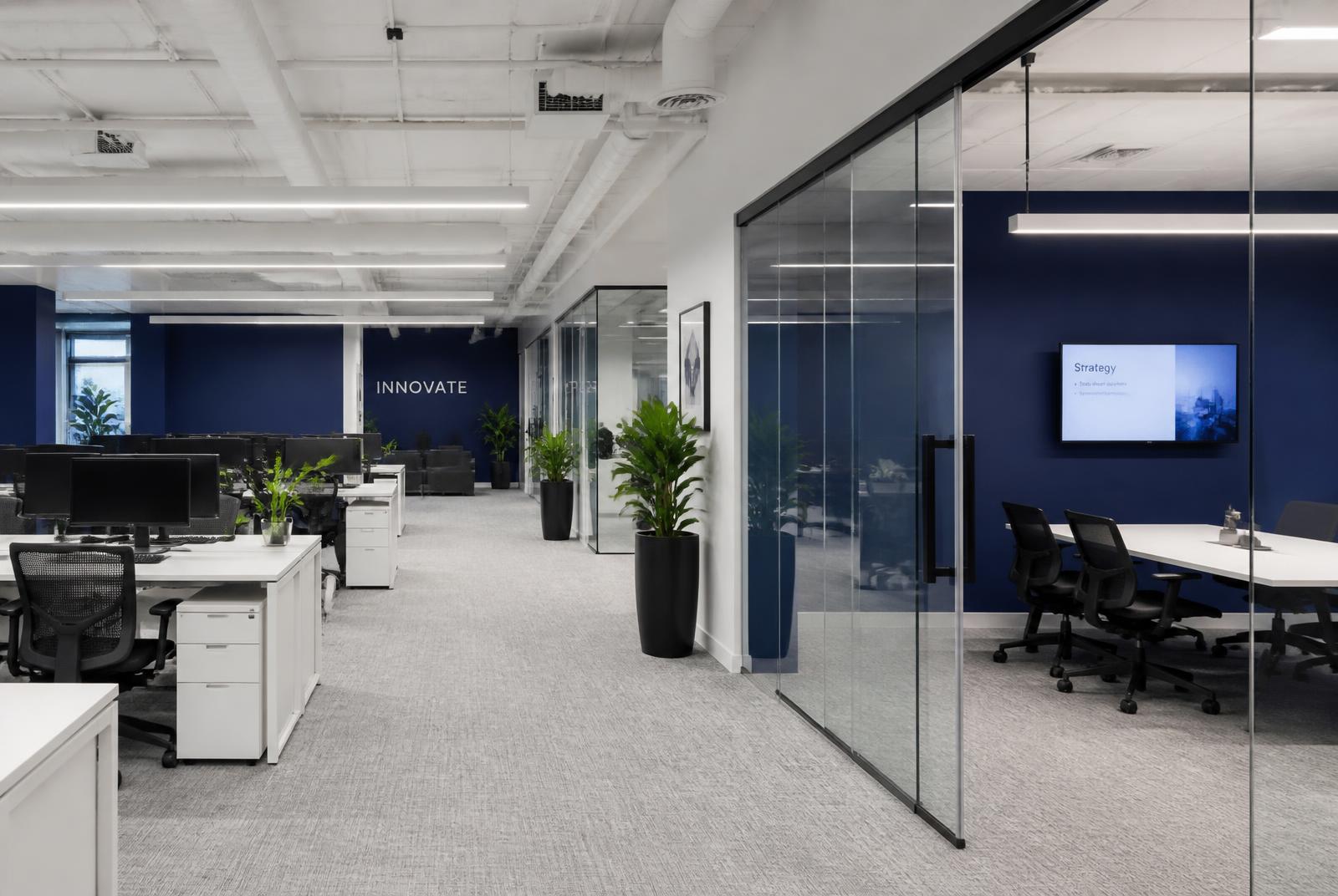 Bright open-plan office with collaborative desks and glass meeting rooms